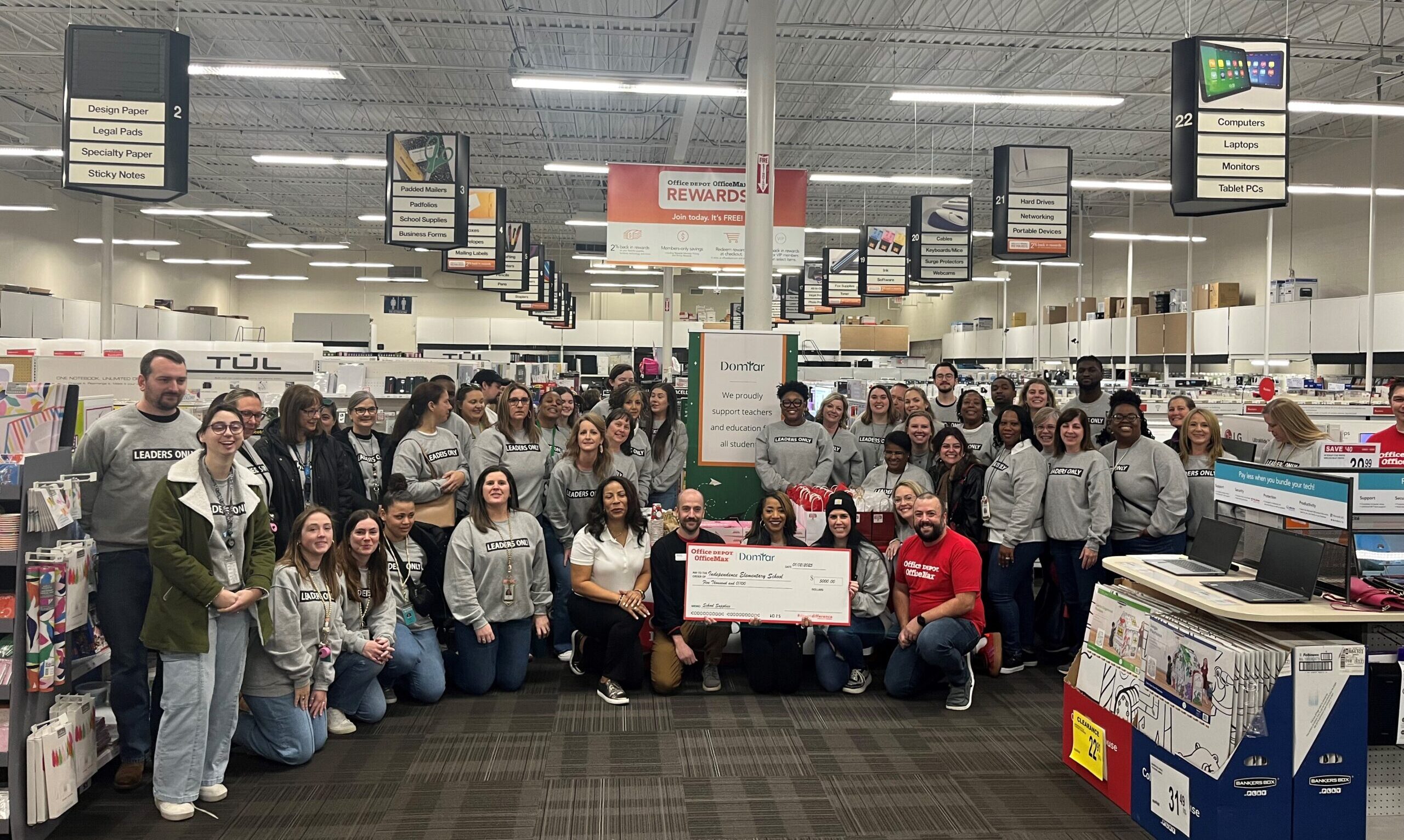 The Office Depot Start Proud! program is one of Domtar's key charitable partnerships supporting education. Image includes large group of people (teachers, representatives from Office Depot and Domtar) in an office supply store holding a check to Independence Elementary School for $5,000 US.